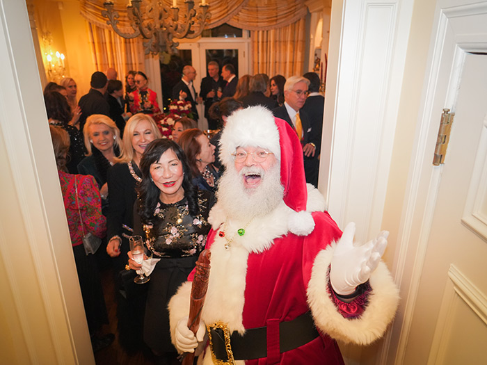 Mickey Heller brings holiday cheer as Santa, posing with guests.